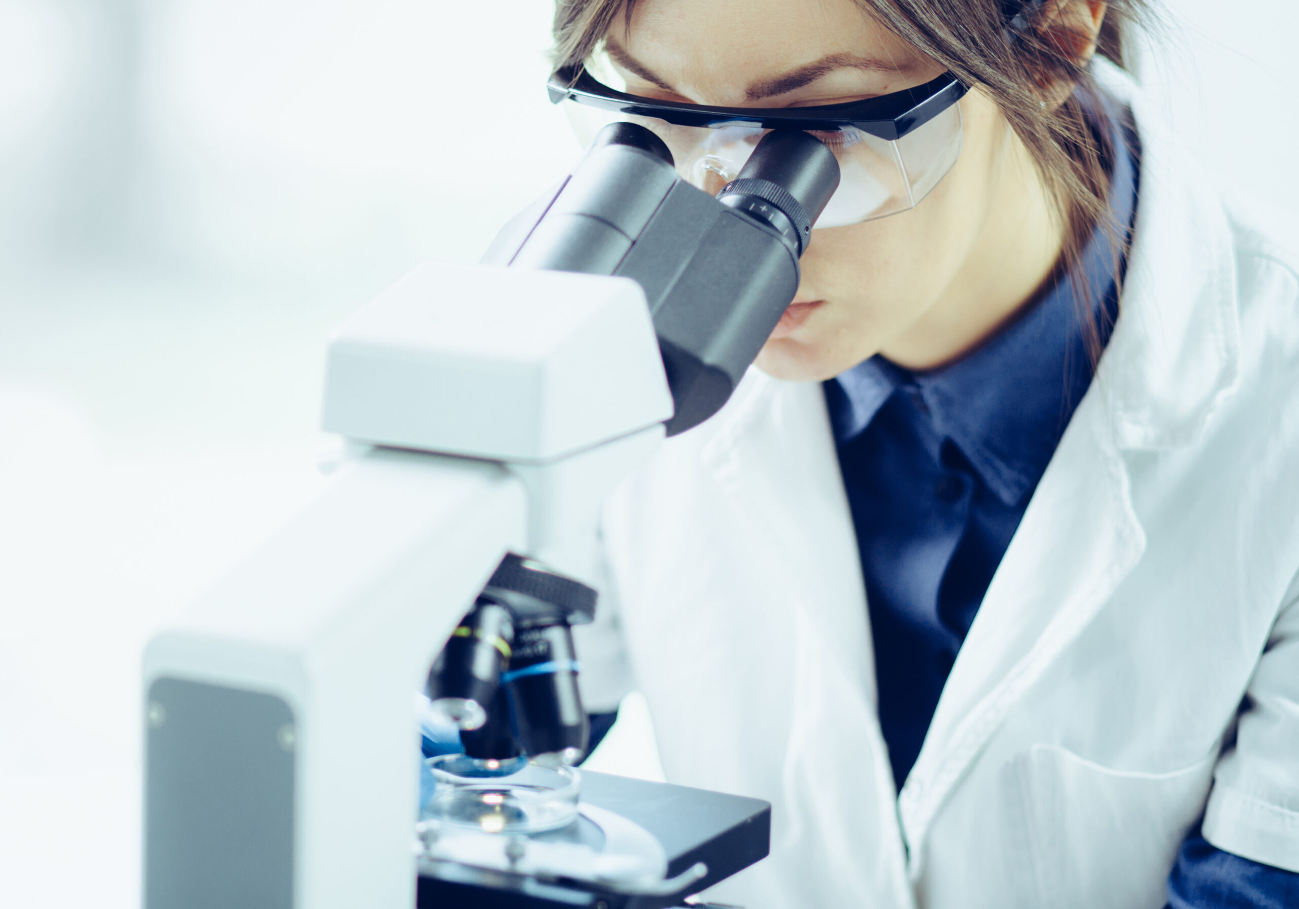 Young,Scientist,Looking,Through,A,Microscope,In,A,Laboratory.,Young Young,Scientist,Looking,Through,A,Microscope,In,A,Laboratory.,Young